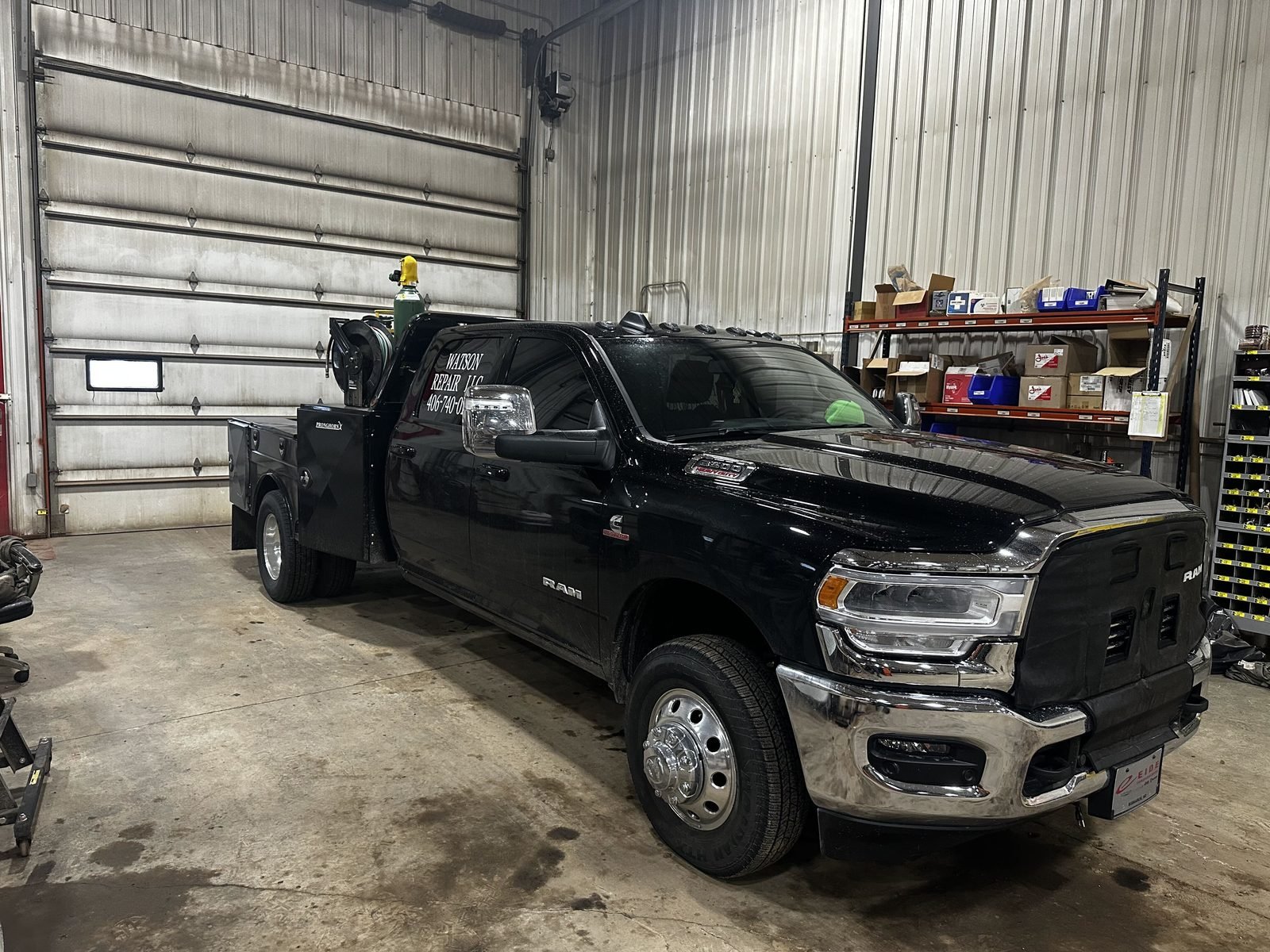 Watson Repair's black mobile service truck parked in the shop